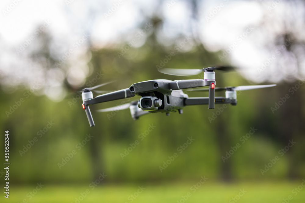 Quadcopter flying on a clear sunny green day background