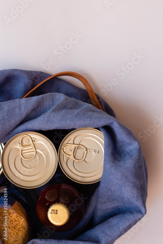 the shopping bag with non-perishable products - canned goods,  pasta, tomato paste and flour. Purchase of food during quarantine