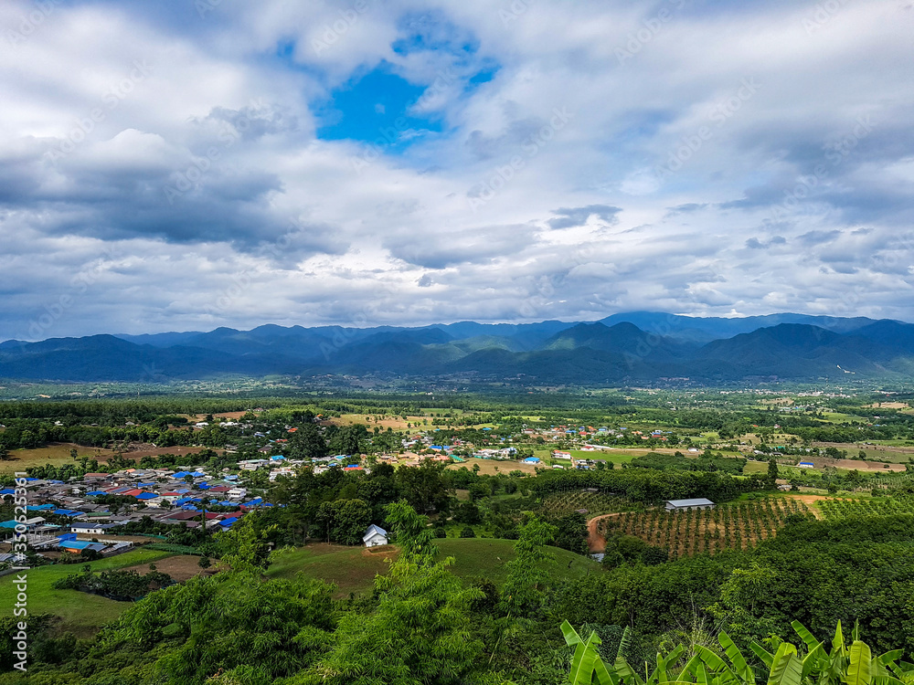 White clouds pai village blue roofs houses fields plants nature outside mountains background warm sky chiang mai north