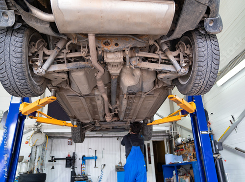 Inspection of the undercarriage of the car in the garage.  photo