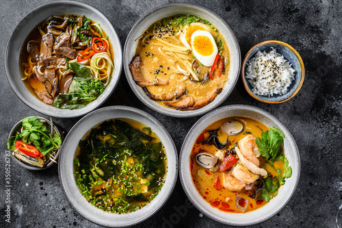 Assorted traditional Asian soups. Miso, Ramen, Tom Yam, Pho Bo. Black background. Top view