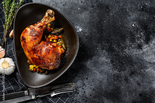 Grilled chicken legs with spices and garlic. Black background. Top view. Copy space