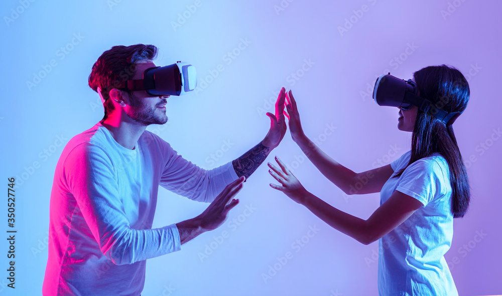 Fototapeta premium Love and modern technology. Couple in virtual glasses touch each other with hands