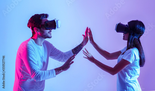 Love and modern technology. Couple in virtual glasses touch each other with hands