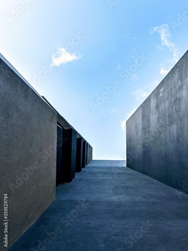 Dark grey walls leading into an expansive blue sky
