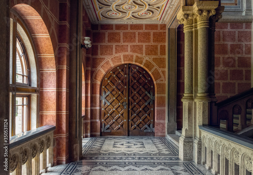 Chernivtsi city, Bukovina, Ukraine - June 12, 2018: ancient wrought-iron door and a marble staircase in the lobby of the old university building in the city of Chernivtsi. Medieval architecture
