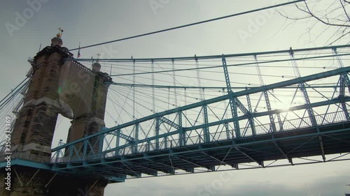 Looking up at John A. Roebling suspension bridge and bright white sun, parallax photo
