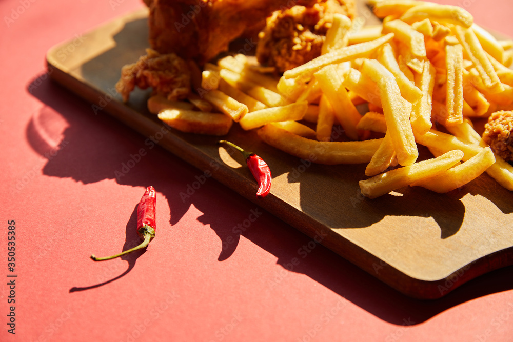Φωτογραφία selective focus of spicy deep fried chicken and french fries served on wooden cu