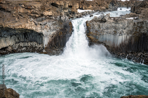 Aldeyjarfoss waterfall canyon in the highlands of Iceland. Basalt columns and powerful water flow on a sunny day.