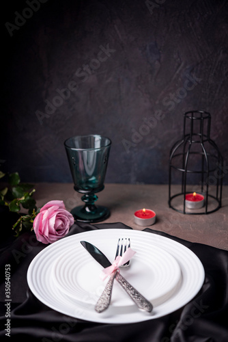 Cutlery on plates with rose and candles