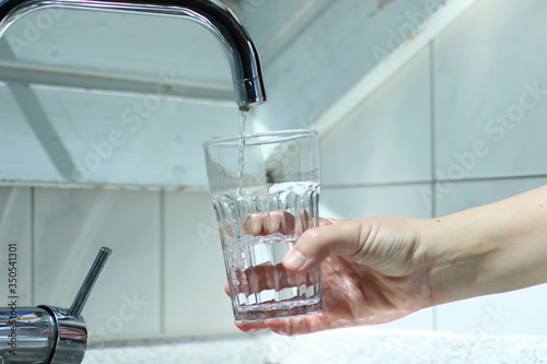 Wasser in das Glas gießen