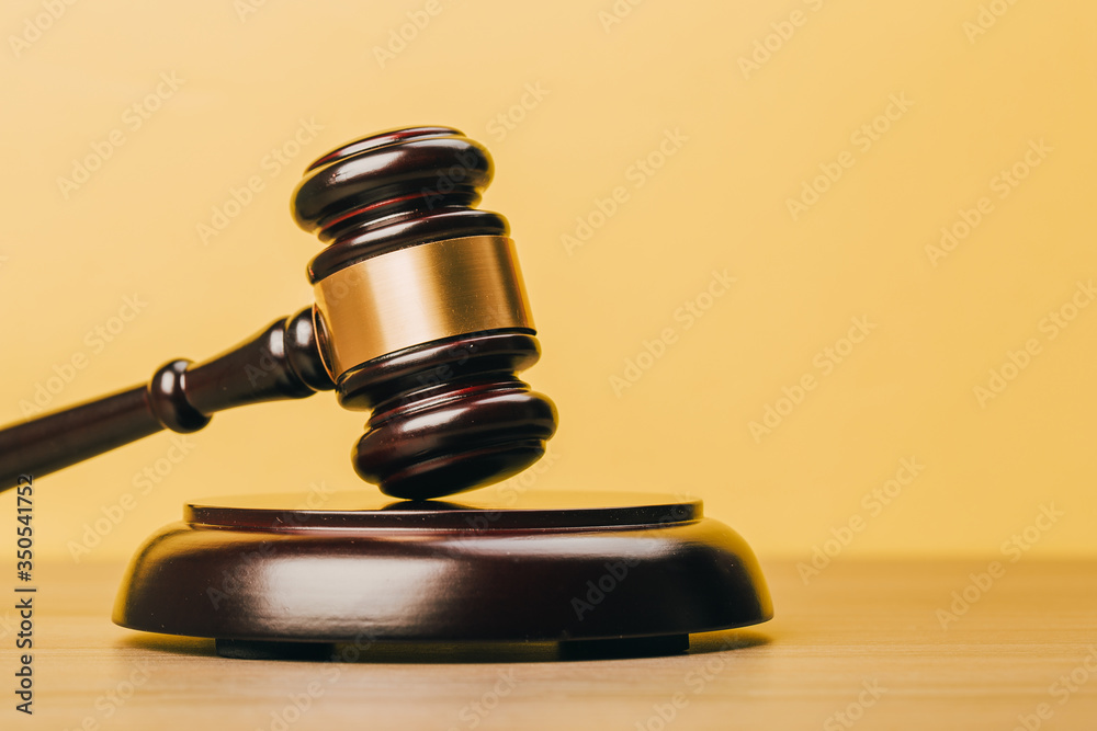 Judge Gavel on a wooden table and yellow-orange background. Judge Gavel on a wooden table and yellow-orange background.