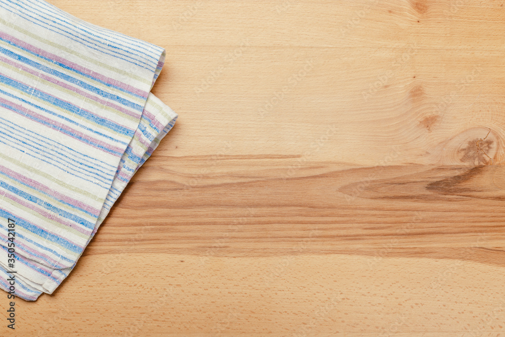 Top view on a wooden table with a linen kitchen towel or textile napkin. Top view on a wooden table with a linen kitchen towel or textile napkin.