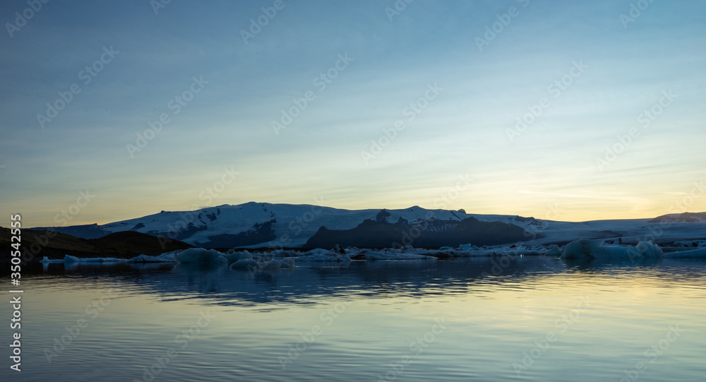 Fjallsarlon, Jokulsarlon glacier lagoon in Iceland during blue hour and sunset. Wanderlust and holiday concept.