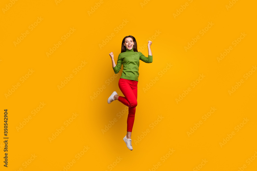 Full length photo of positive cheerful girl celebrate lottery win raise fists scream yeah feel crazy emotions ear good looking clothing isolated over vivid color background