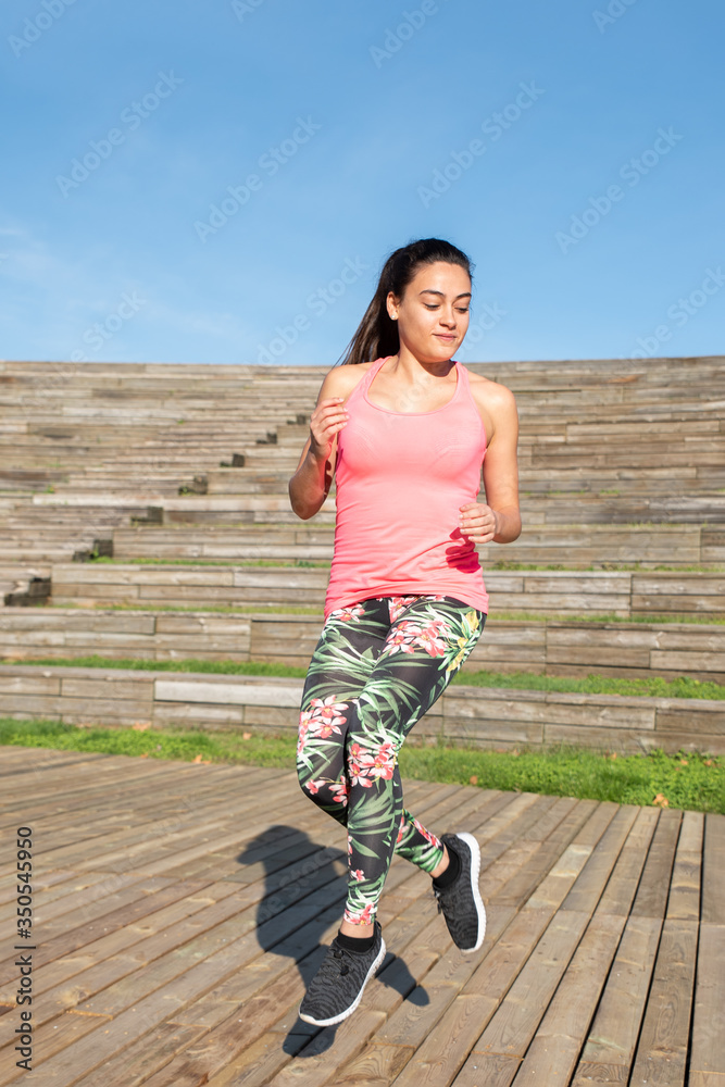 Fototapeta premium Woman doing exercise, skipping outdoors