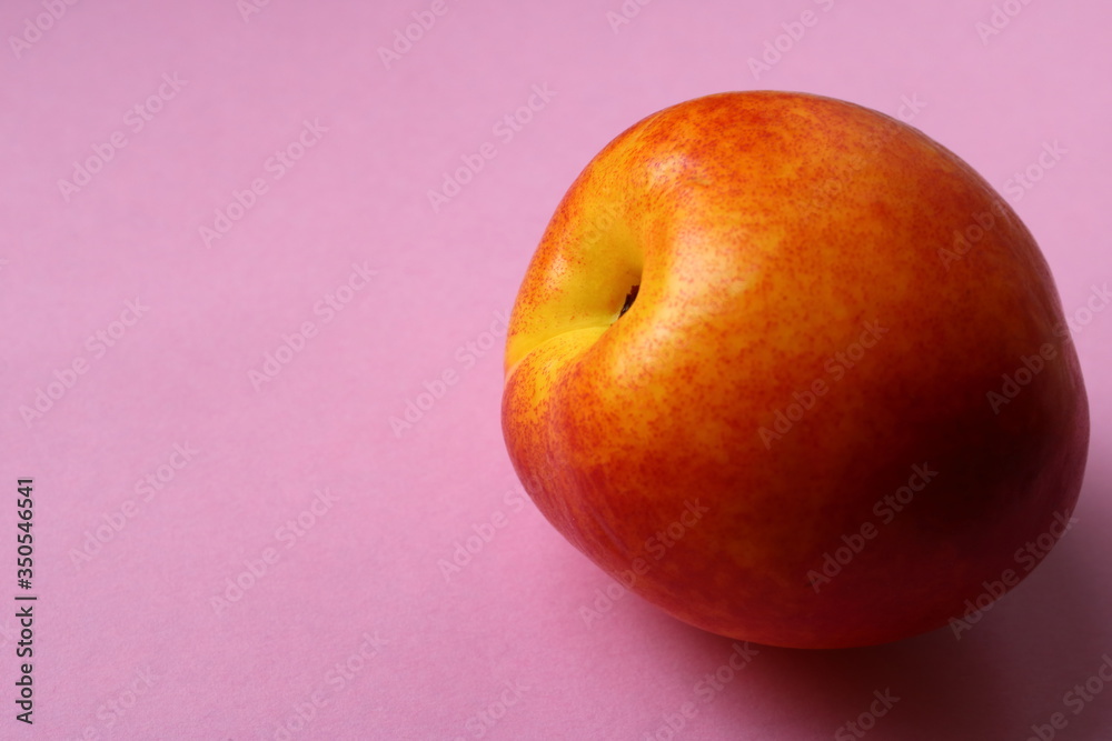 nectarine fruit, peach on a pink background nectarine fruit, peach on a pink background