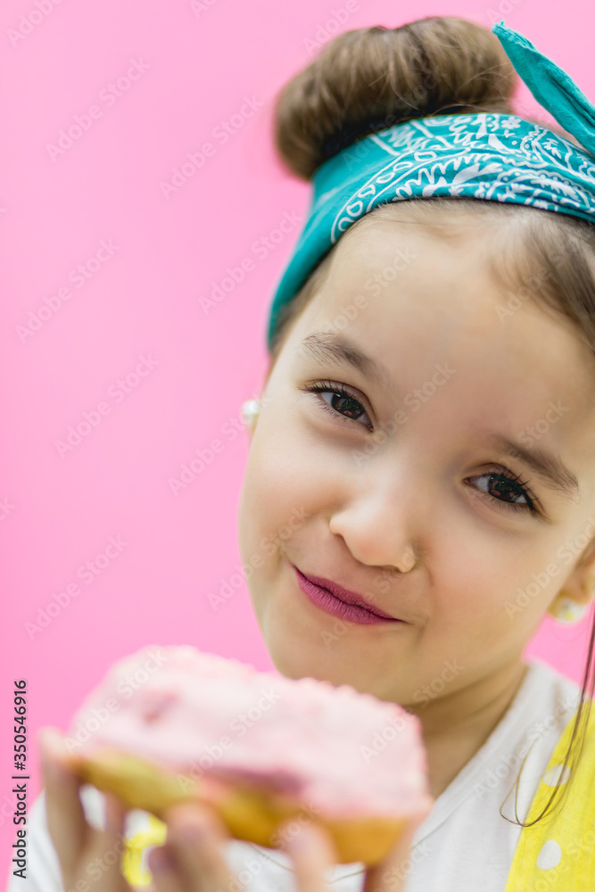 Attractive girl holding a glazed pink donut in hands. Attractive girl holding a glazed pink donut in hands.