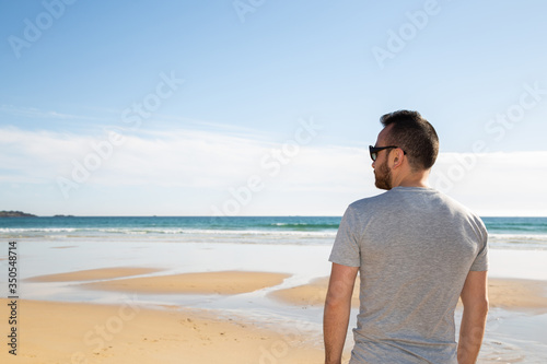Boy on a beach looking at the horizon