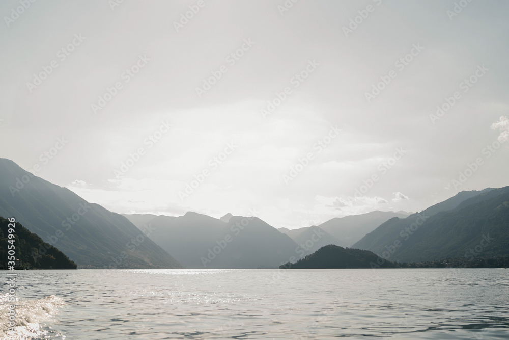 Natural landscapes of a mountain lake Como, Italy. Lake Como surrounded by mountains at sunset. The mountains. Sky. Sunset