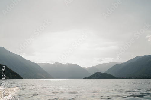 Natural landscapes of a mountain lake Como, Italy. Lake Como surrounded by mountains at sunset. The mountains. Sky. Sunset © Elena