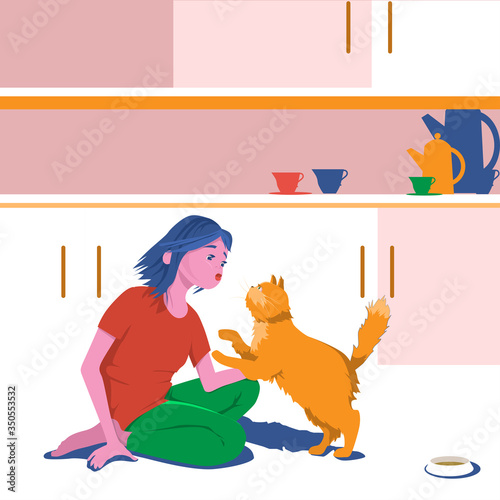 Girl hugs domestic cat at home in the kitchen.