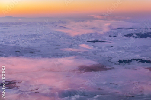 Sunrise over Caucasus Mountains seen from passenger plane window © Fotokon