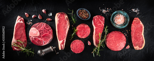 Panel kuchenny z motywem Various cuts of meat, shot from above on a dark background with condiments, a flat lay panorama