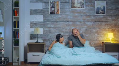 Fotografija Young man waking up his girlfriend after a scary nightmare, Confused female