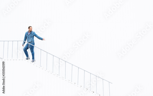 The man on top of the stairs on a white background holds out his hand. Top of the career ladder. The guy goes up the stairs. A man holds out a helping hand.