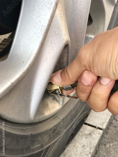 Holding the inflator in order to check the tire pressure is the reason for  controlling the pressure, reducing the risk of the accidents, and saving fuel consumption.