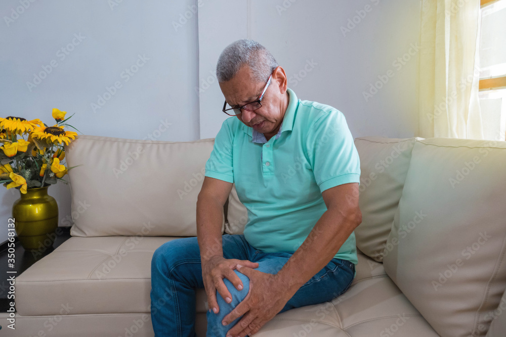 people, health care and concept medical problem - unhappy older man suffering from knee pain at home