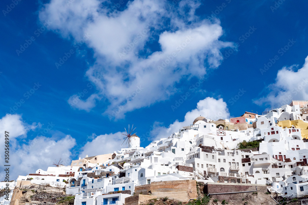 Low angle view of white houses near windmill in Greece