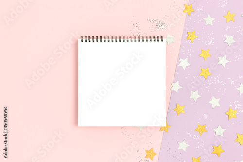 Empty notepad mockup on a pink pastel background. Stars confetti texture. Festive glowing concept. © rorygezfresh