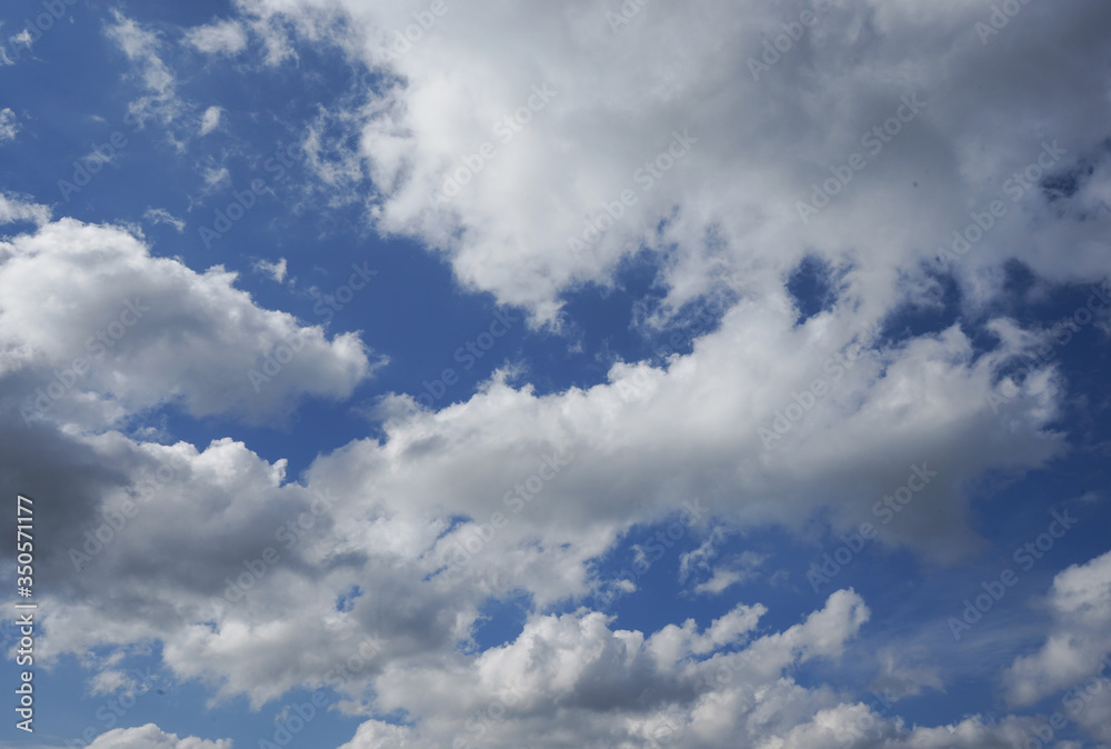 Fototapeta premium White clouds spread all over the blue sky creating a contrast and an abstract pattern