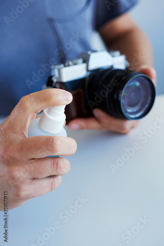 man disinfecting his camera