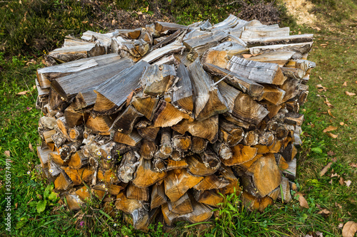 A pile of firewood stacked in round cluster.