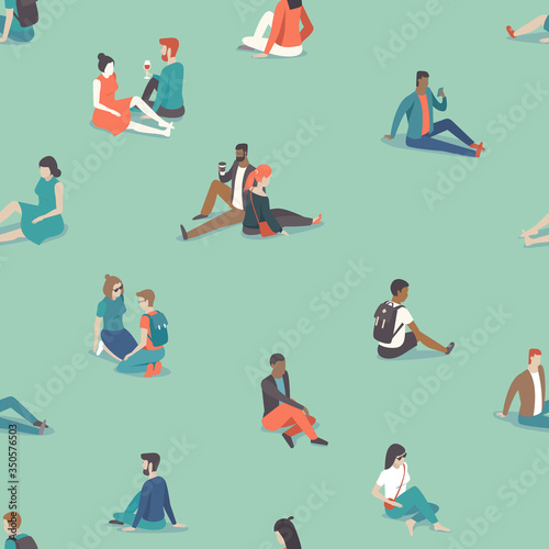 Social distancing in the park during coronavirus COVID-19 disease oubreak. People relaxing on the grass keep distance from each other.