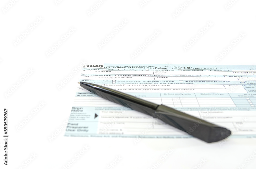 tax form 1040 and pen on white .Financial document. tax form 1040 and pen on white .Financial document.