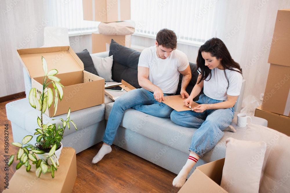 Happy young couple unpacking or packing boxes and moving into a new home. Happy young couple unpacking or packing boxes and moving into a new home.