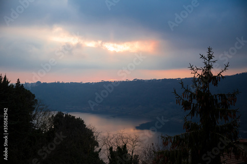 Beautiful view of lake and forest in the foggy evening. Sunset and haze in the beautiful landscape. Rest and peace during the trip through the mountains. Soft focus and medium sharp photo of nature