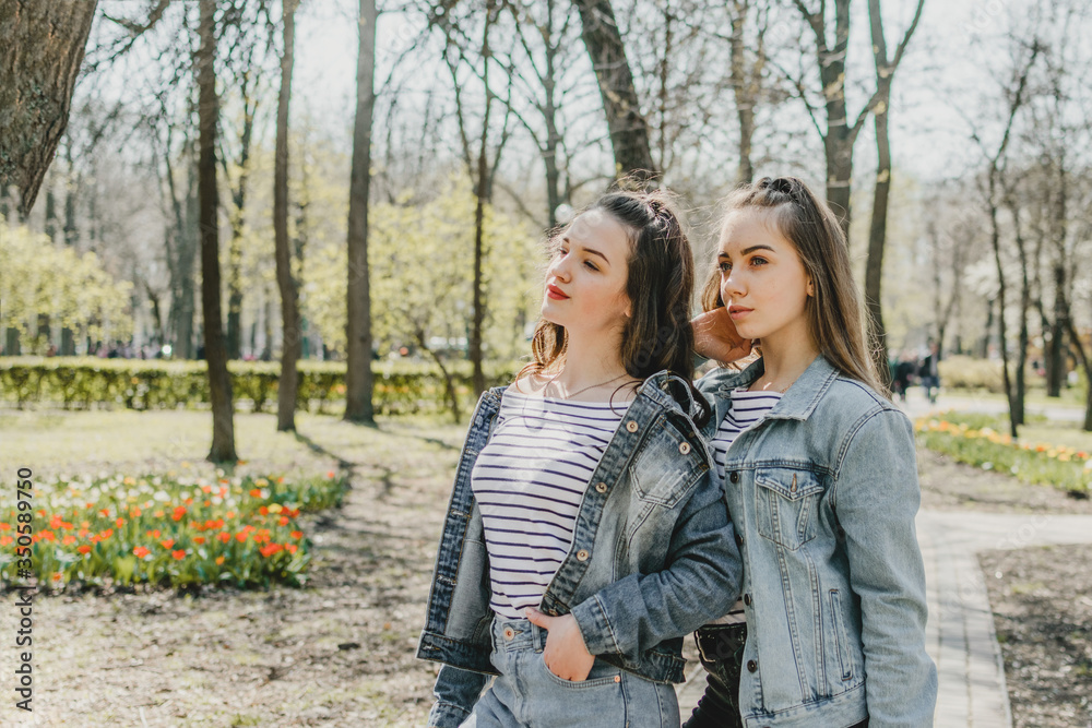Fototapeta premium Generation Z, gen z, Homelanders, Homeland Generation, Zoomers, New Silent Generation. Two young Happy girls friends having fun in the summer park