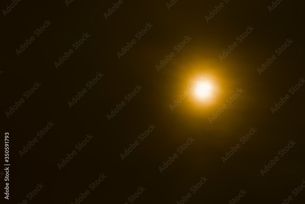 bright orange sun in darkness on abstract background