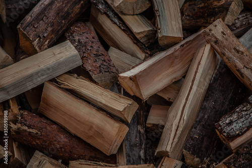 Trees in the sawmill are stacked in bags for sell. Stacks of firewood. Preparation of firewood for the winter. A heap of woodpile. Chopped wood. Firewood.Pile of wood logs ready for winter
