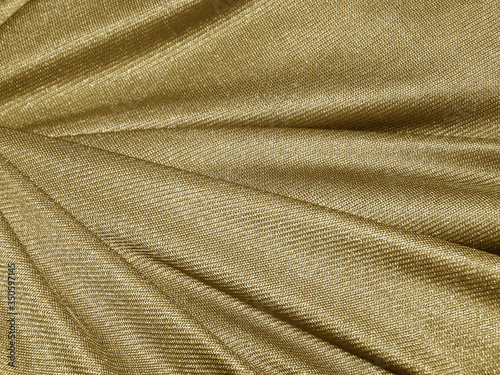 Folds of golden fabric texture background