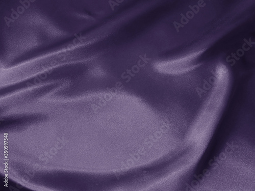 Shiny violet crumpled fabric background. Liquid wavy shape.