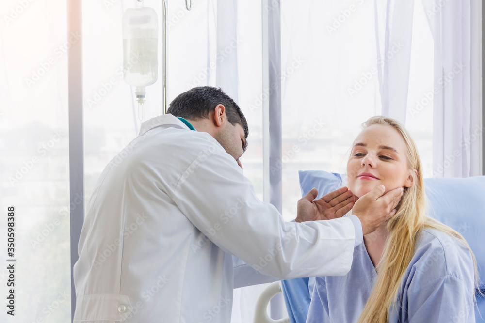 Fototapeta premium male doctor examined the neck pain of a female patient sitting in hospital bed