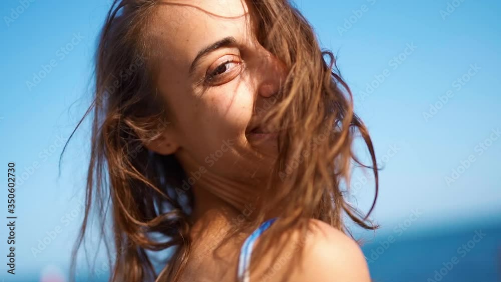 super slow motion Close Up attractive smiling woman with flying hair over face. girl face on blue sky background, wind blowing hair summertime super slow motion Close Up attractive smiling woman with flying hair over face. girl face on blue sky background, wind blowing hair summertime