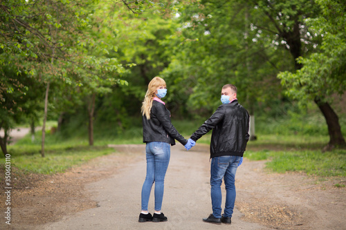  couple in love walks in a masked park, isolation, coronavirus