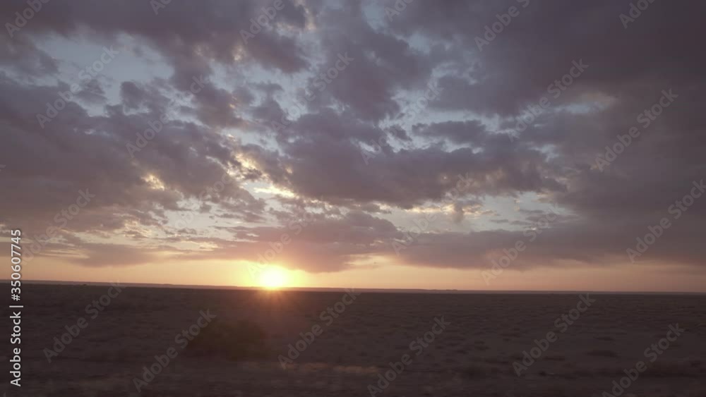 Panning shot of sun and clouds against sky during sunset seen through train window - Swakopmund, Namibia Panning shot of sun and clouds against sky during sunset seen through train window - Swakopmund, Namibia